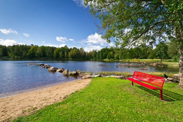 Czerwona ławka na jezioro w Szwecji — Zdjęcie stockowe