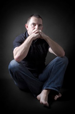 düşük anahtar karanlıkta oturan adam portresi