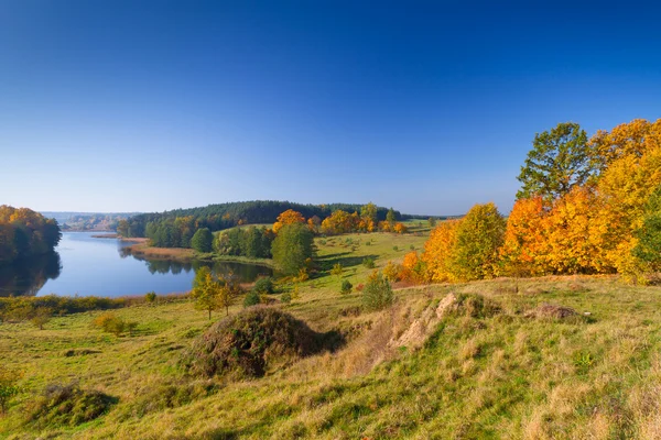 Herbstliche Landschaft aus Wiese und See — Stockfoto