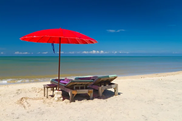 Kırmızı şemsiye ile tropik sahilde şezlong — Stok fotoğraf