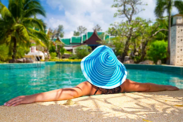 Mulher de chapéu relaxante na piscina — Fotografia de Stock