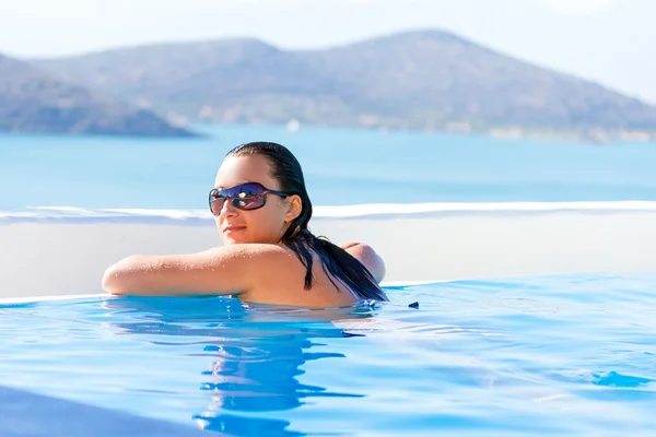 Young woman relaxing at swimming pool — Stock Photo, Image