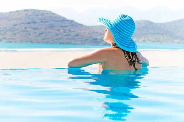 Woman in hat relaxing at swimming pool — Stock Photo, Image