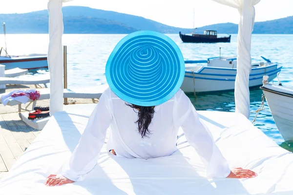 Donna in cappello rilassante sul letto bianco di lusso — Foto Stock