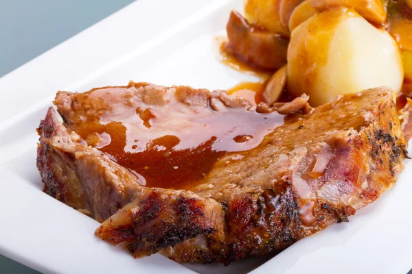 Roast pork with gravy and potatoes — Stock Photo, Image