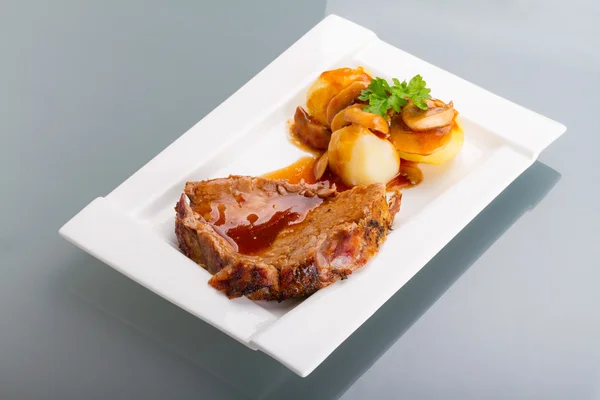 Porco assado com molho e batatas — Fotografia de Stock