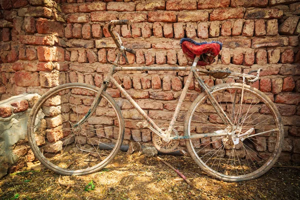 Polvorienta bicicleta vieja en la pared de ladrillo — Foto de Stock