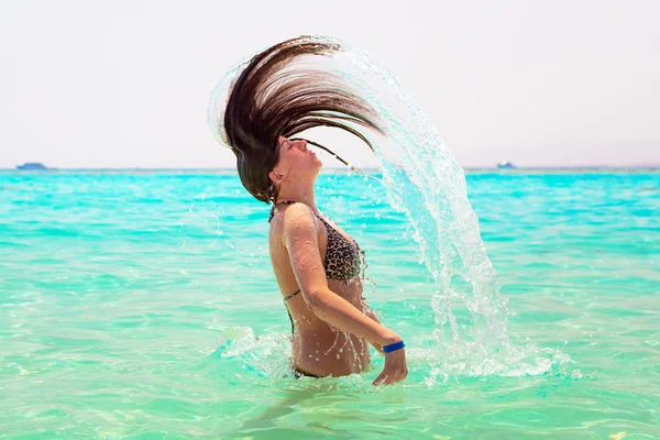 Jonge brunette springen uit turquoise water van de rode zee — Stockfoto