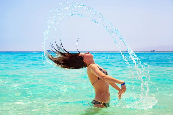 Young brunette jumping out of turquoise water of Red Sea — Stock Photo, Image