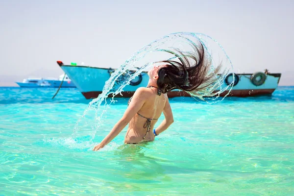 Young brunette jumping out of turquoise water of Red Sea — Stock Photo, Image