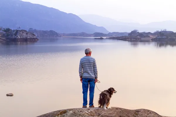 Old man with the dog at the lake — Stock Photo, Image