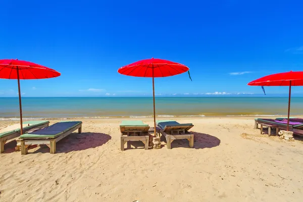 Красный зонтик с шезлонгом на тропическом пляже — стоковое фото