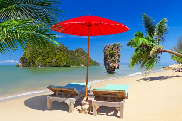 Tropical beach scenery with parasol and deck chairs — Stock Photo, Image