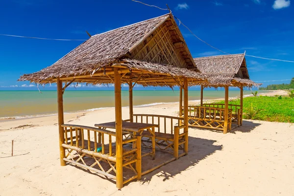 Paesaggio tropicale sulla spiaggia con piccole capanne — Foto Stock