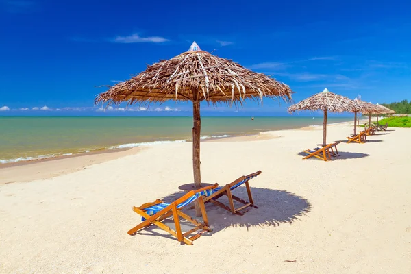 Tropisch strand landschap met parasol en ligstoelen — Stockfoto