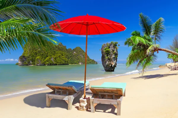 Tropical beach scenery with parasol and deck chairs — Stock Photo, Image