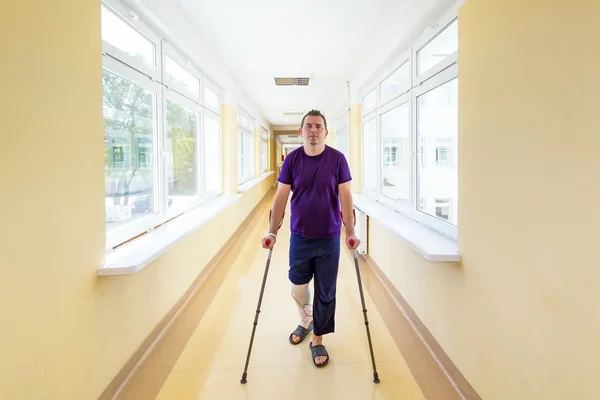 Man walks on crutches — Stock Photo, Image