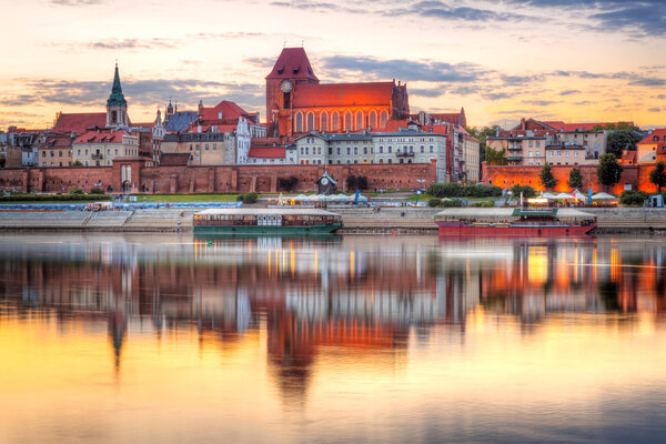 Torun old town reflected in Vistula river at sunset