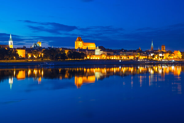 Torun old town at night reflected in the river