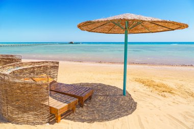 Plajda şemsiye altında dinlenmek