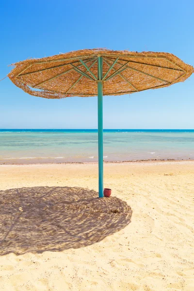 Relájese bajo la sombrilla en la playa — Foto de Stock