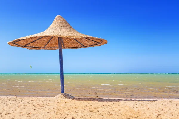Ontspan onder parasol op het strand — Stockfoto