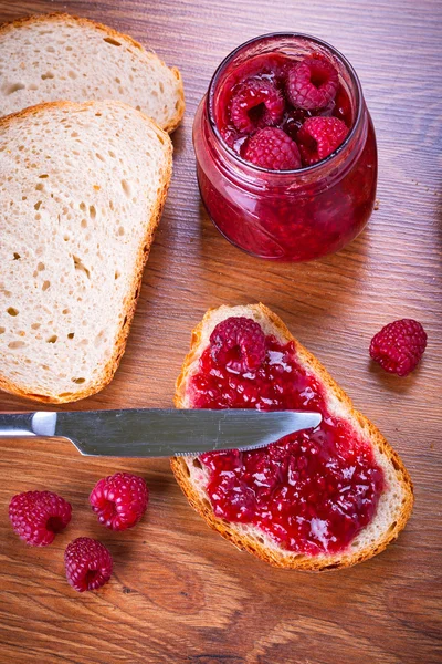 Engarrafamento de Rapsberry com parte de pão — Fotografia de Stock