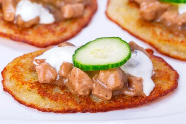 Potato pancakes with chicken and mushrooms sauce — Stock Photo, Image