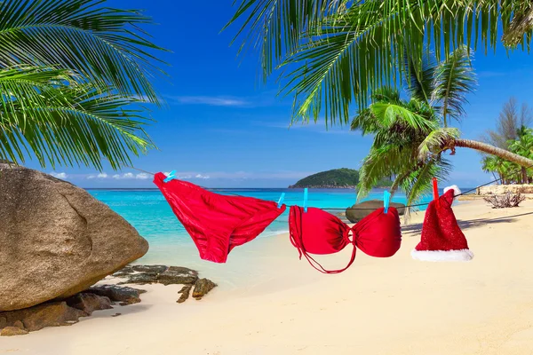 熱帯のビーチでサンタ帽子と赤いビキニ — ストック写真