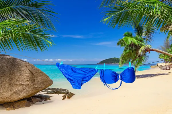 Bikini colgado de una cuerda en la playa tropical — Foto de Stock