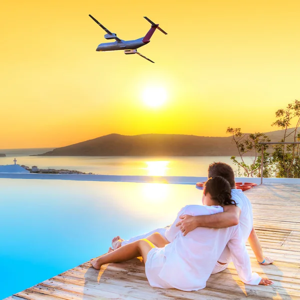 Couple in hug watching airplane at sunset Royalty Free Stock Photos