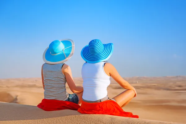 Duas garotas com chapéus relaxantes no deserto — Zdjęcie stockowe