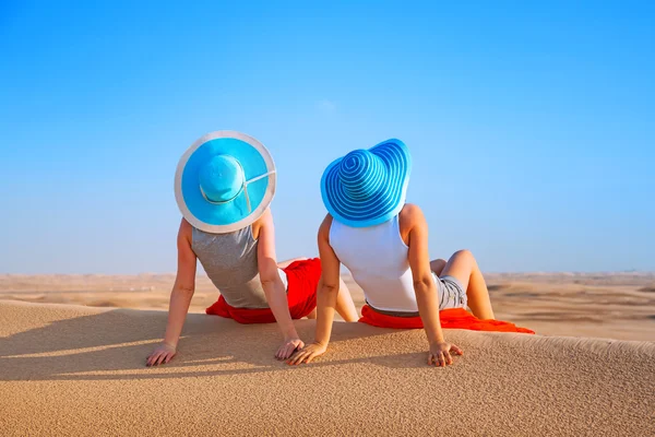 Duas meninas de chapéu relaxando no deserto — Fotografia de Stock