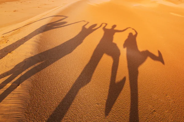 Shadow silhouettes of four people in the desert — Stock Photo, Image