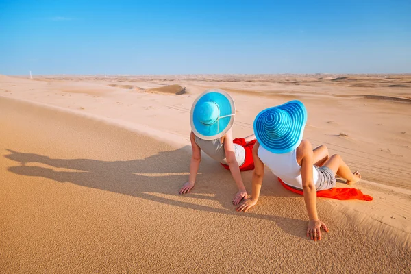 Duas garotas com chapéus relaxantes no deserto — Zdjęcie stockowe