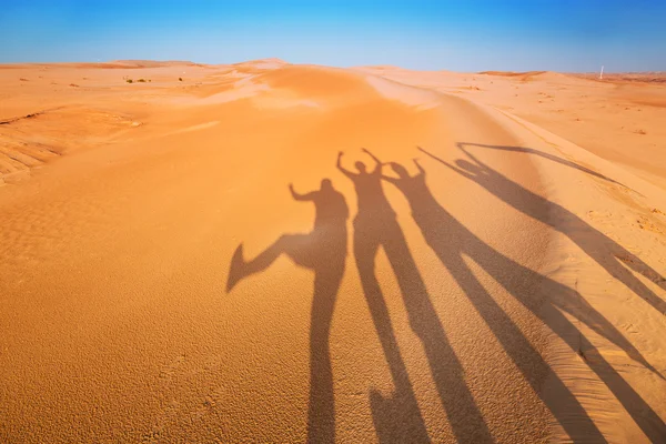 Silhuetas de sombras de quatro pessoas no deserto — Fotografia de Stock