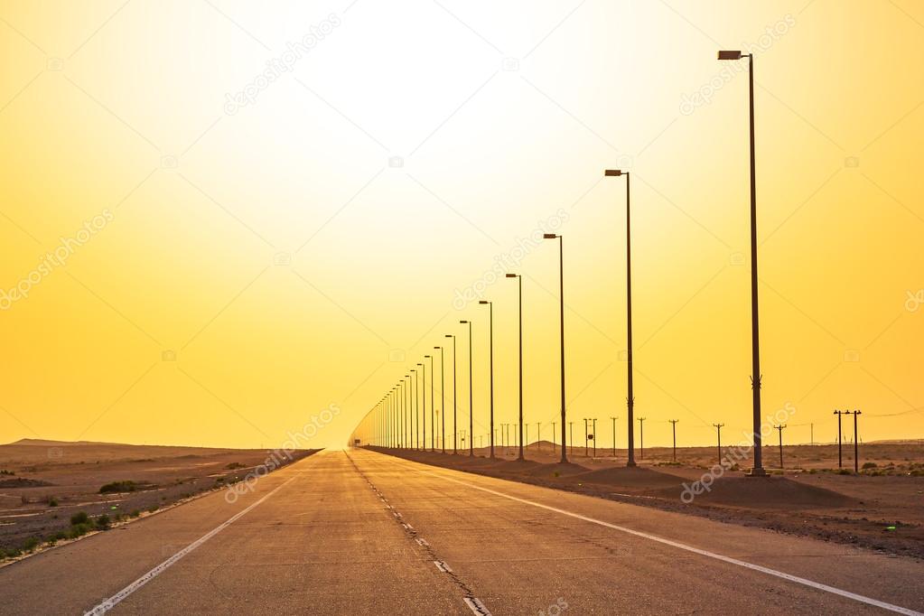 Empty road in the desert at sunset