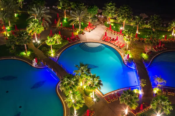 Zona de piscina tropical por la noche — Foto de Stock