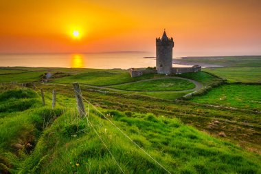 Doolin, Co. Clare, İrlanda 'daki Atlantik Okyanusu' ndaki Doonagore kalesi.