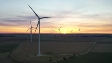 Polonya 'da rüzgar türbinleriyle sahada inanılmaz bir gün batımı.