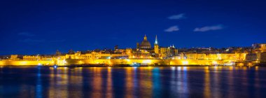 Malta kıyıları ve gece Valletta şehrinin mimarisi.