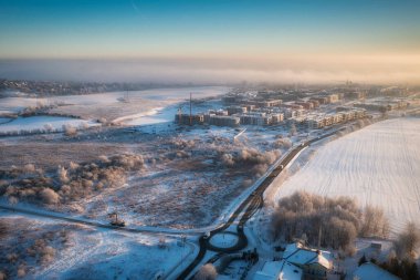 Gün doğumunda taze karla kaplı küçük bir köyün havadan manzarası