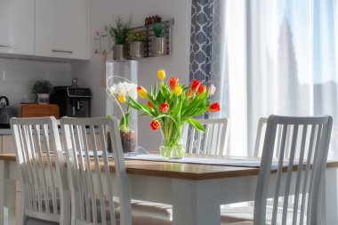 Yemek masasında bir buket bahar lalesi.