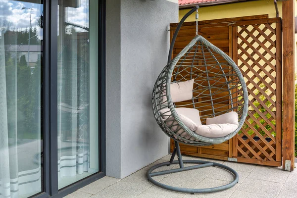 夏天花园阳台上挂着灰色枕头的现代藤椅 — 图库照片