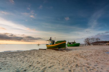 Beautiful landscape of the beach with fishing boats at sunrise in Gdynia Orlowo. Poland
