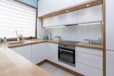 Modern white kitchen interior with wooden worktops
