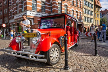 Gdansk, Poland - July 29, 2022:  Red tourist car for exploring the old town of Gdansk, Poland