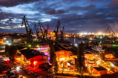 Gdansk, Poland - September 2, 2022: Gdansk shipyard scenery (Stocznia or 100cznia in polish means shipyard) with retro-lighted clubs and bars at dusk, Poland. clipart