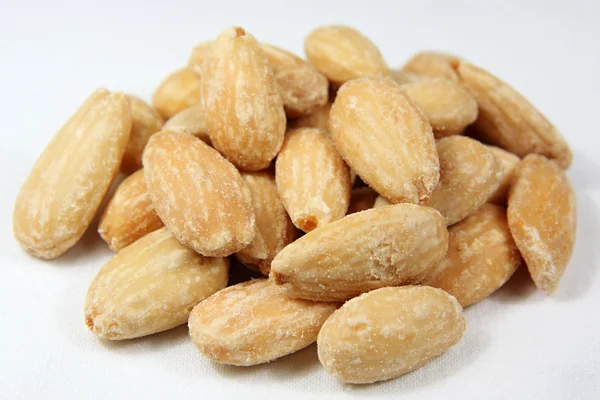 Almonds heap against white background — Stock Photo, Image