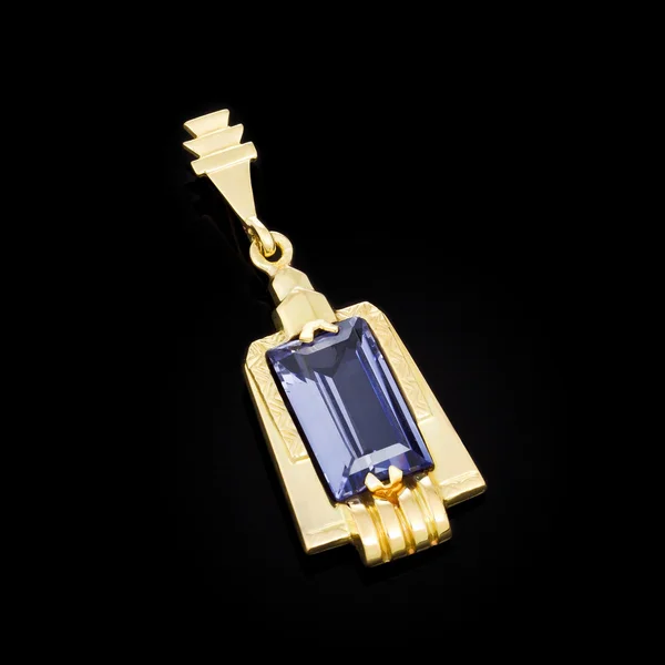 Gold pendant with blue stone on black background — Stock Photo, Image